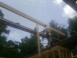 Carpenter setting a ridge beam over a new addition frame — Ice Dam Removal by Roofing Brothers in Santaquin