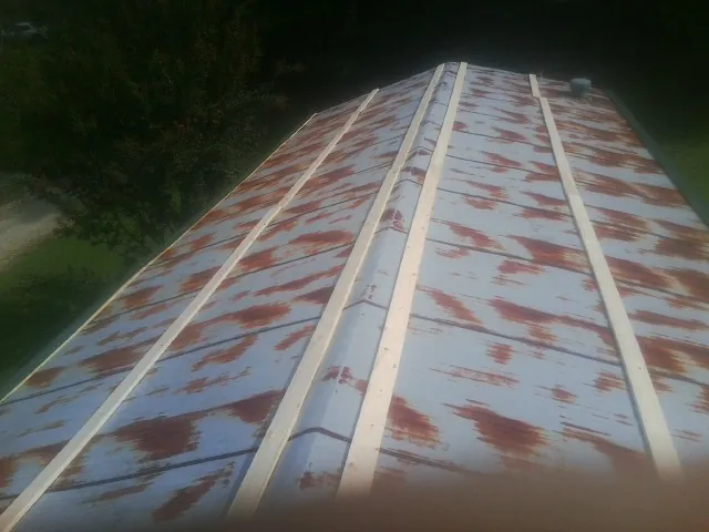 Rusted metal roof panels with new wood purlins before replacement — Storm Damage Roof Repair in Santaquin by Roofing Brothers
