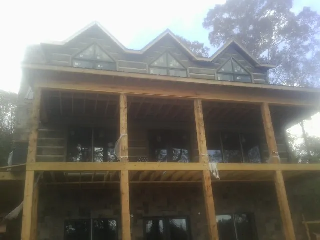 Dormers and porch framing on a large log home under construction — Roof Coating work by our crew in Santaquin